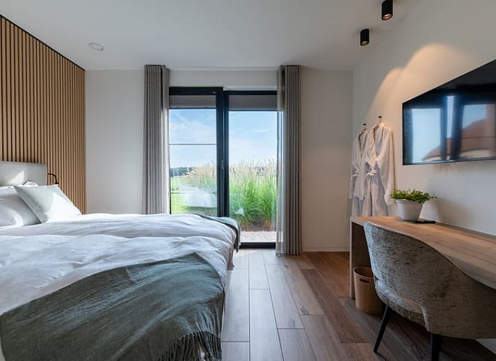 Geniessen Sie die Entspannung im Whirlpool im Ferienhaus in Kasterlee, Antwerpen, Belgien, umgeben von gruener Natur und rustikalem Charme.