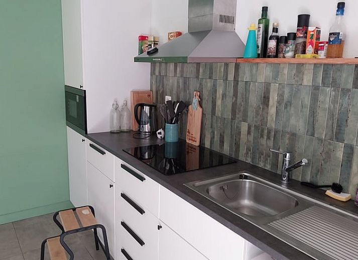 Gemuetlicher Innenbereich des Ferienhauses in Herselt, Antwerpen, Belgien, mit Holzwaenden und einem Brettspiel auf dem Tisch.