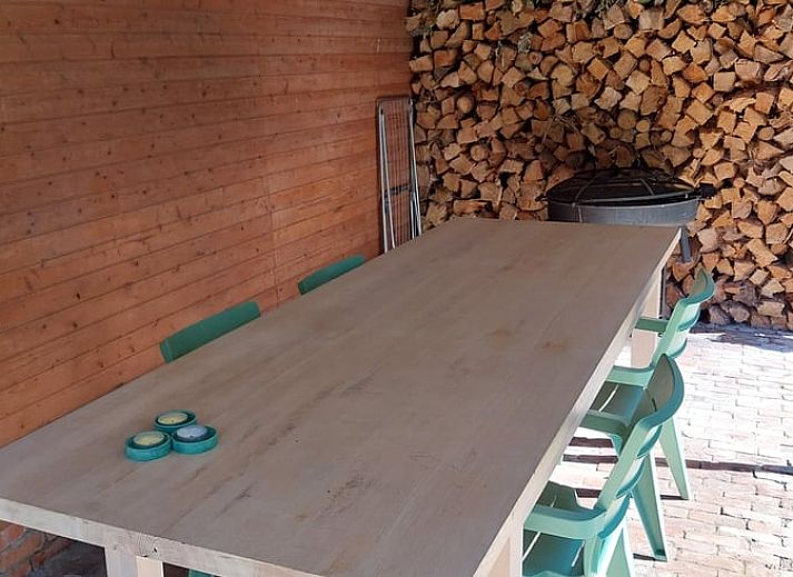 Gemuetliches Wohnzimmer im Ferienhaus in Herselt, Antwerpen, Belgien, mit bequemen Stuehlen und einem gemuetlichen Kamin.