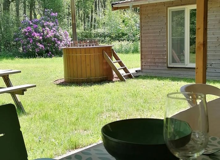 Gemuetliches Wohnzimmer im Ferienhaus in Herselt, Antwerpen, Belgien, mit bequemen Stuehlen und einem gemuetlichen Kamin.