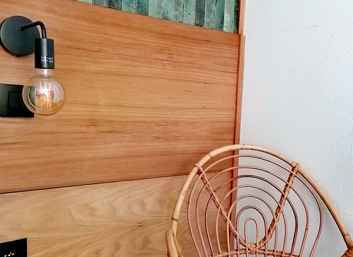 Gemuetliches Wohnzimmer im Ferienhaus in Herselt, Antwerpen, Belgien, mit bequemen Stuehlen und einem gemuetlichen Kamin.