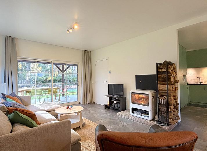 Cozy living room in Lierelodge vacation home, Oud-Turnhout, with wood stove and view of the green garden from the comfortable sitting area.