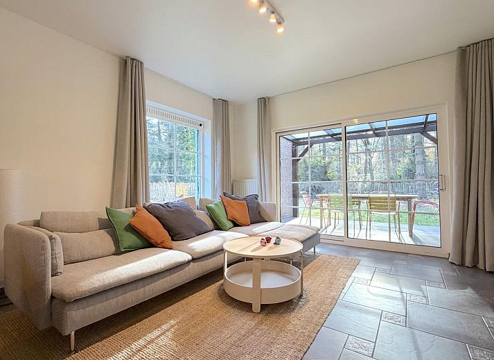Cozy living room in Lierelodge vacation home, Oud-Turnhout, with wood stove and view of the green garden from the comfortable sitting area.