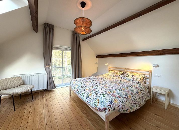 Cozy living room in Lierelodge vacation home, Oud-Turnhout, with wood stove and view of the green garden from the comfortable sitting area.