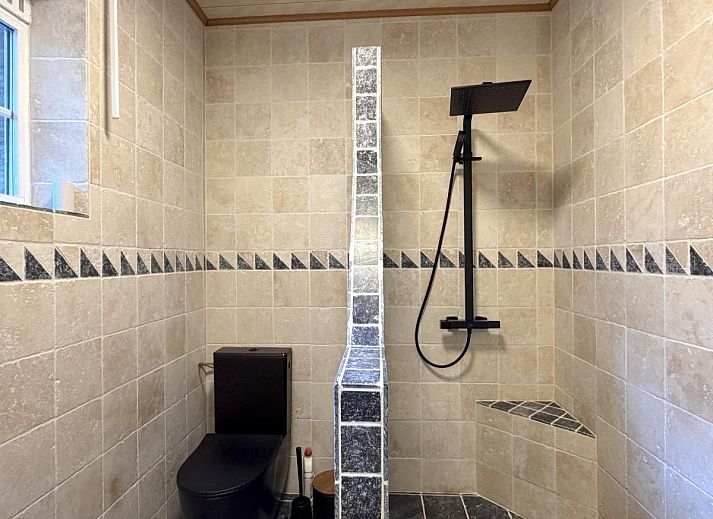 Cozy dining room in Lierelodge vacation home, Oud-Turnhout, Belgium, with wooden furniture and views of the wooded area.