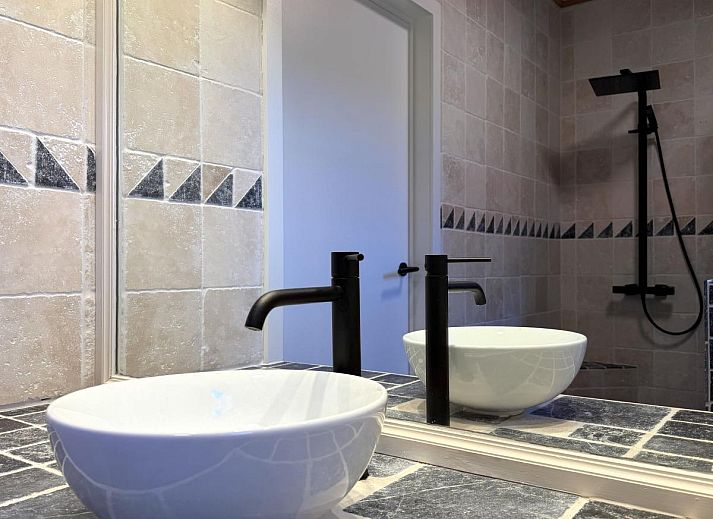 Cozy dining room in Lierelodge vacation home, Oud-Turnhout, Belgium, with wooden furniture and views of the wooded area.