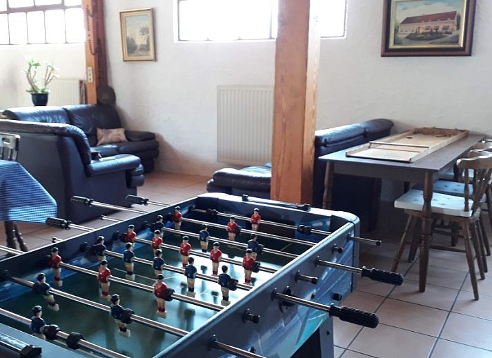 Gemuetlicher Speisesaal in der Fruehstueckspension Moerkantheide in Essen, Antwerpen, Belgien, mit bunten Tischdecken und Holzstuehlen.