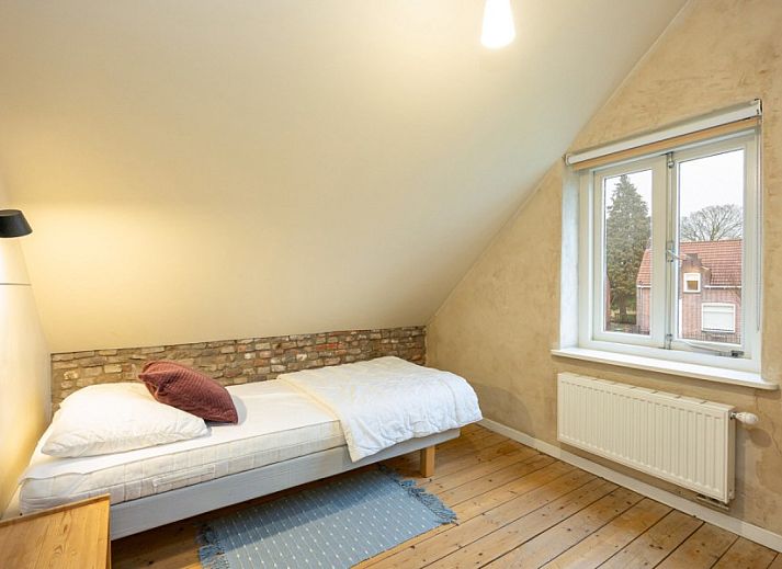 Gezellige woonkamer van vakantiehuis De Morgenstond in Baarle-Hertog, Antwerpen, met comfortabele banken en kleurrijke kunst aan de muur.