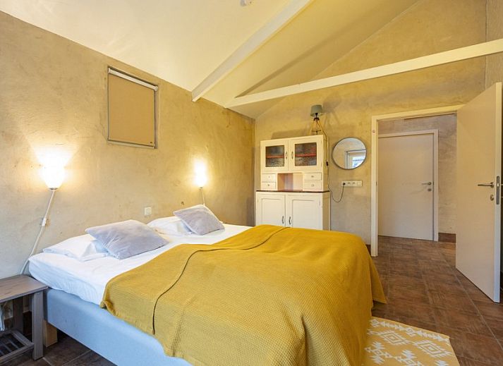 Gezellige woonkamer van vakantiehuis De Morgenstond in Baarle-Hertog, Antwerpen, met comfortabele banken en kleurrijke kunst aan de muur.