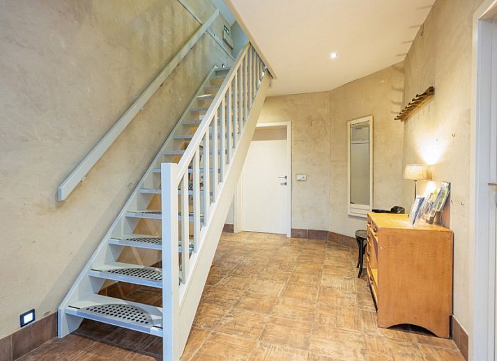 Gezellige woonkamer van vakantiehuis De Morgenstond in Baarle-Hertog, Antwerpen, met comfortabele banken en kleurrijke kunst aan de muur.