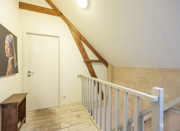 Gezellige woonkamer van vakantiehuis De Morgenstond in Baarle-Hertog, Antwerpen, met comfortabele banken en kleurrijke kunst aan de muur.