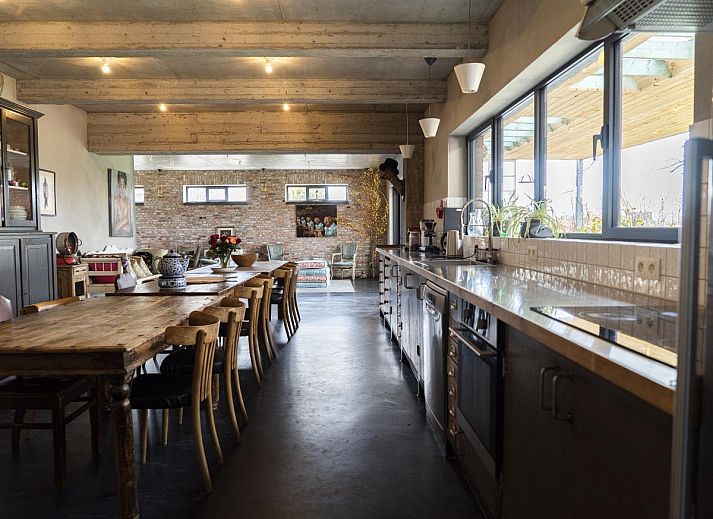 Gezellige eetruimte in vakantiehuis De Lieshoeve, Arendonk, Antwerpen, met prachtig gedekte tafel en kleurrijke details.