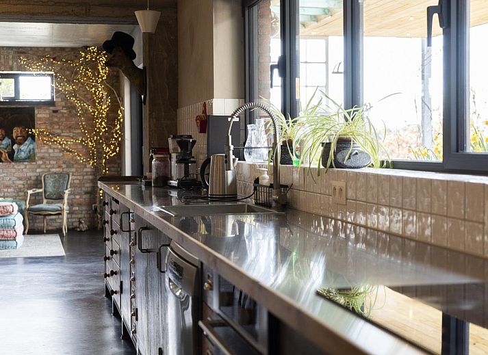 Gezellige eetruimte in vakantiehuis De Lieshoeve, Arendonk, Antwerpen, met prachtig gedekte tafel en kleurrijke details.