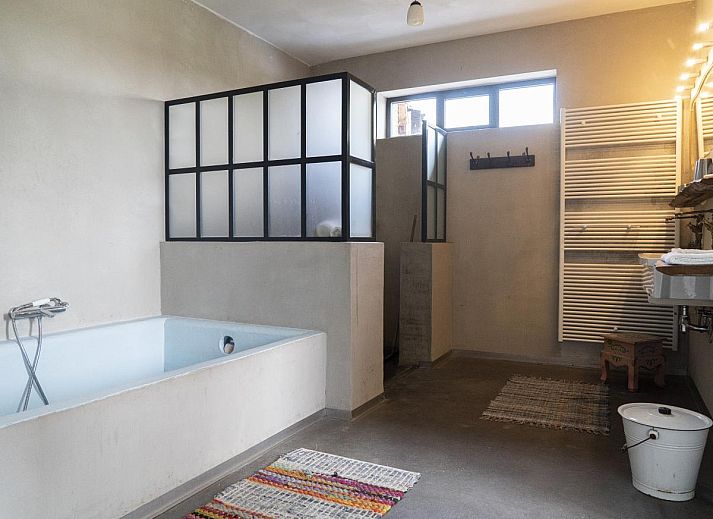 Gezellige woonkamer van vakantiehuis De Lieshoeve in Arendonk, Antwerpen, met vintage meubels en kunst aan de muur.