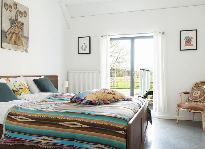 Gezellige woonkamer van vakantiehuis De Lieshoeve in Arendonk, Antwerpen, met vintage meubels en kunst aan de muur.