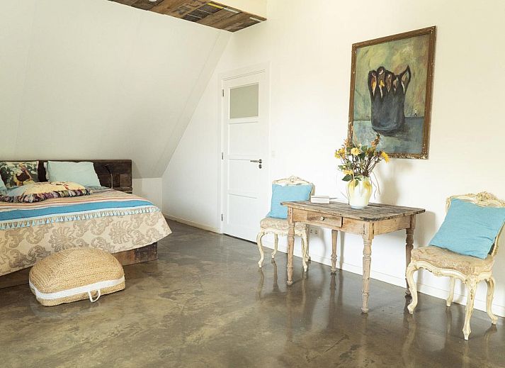 Gezellige woonkamer van vakantiehuis De Lieshoeve in Arendonk, Antwerpen, met vintage meubels en kunst aan de muur.