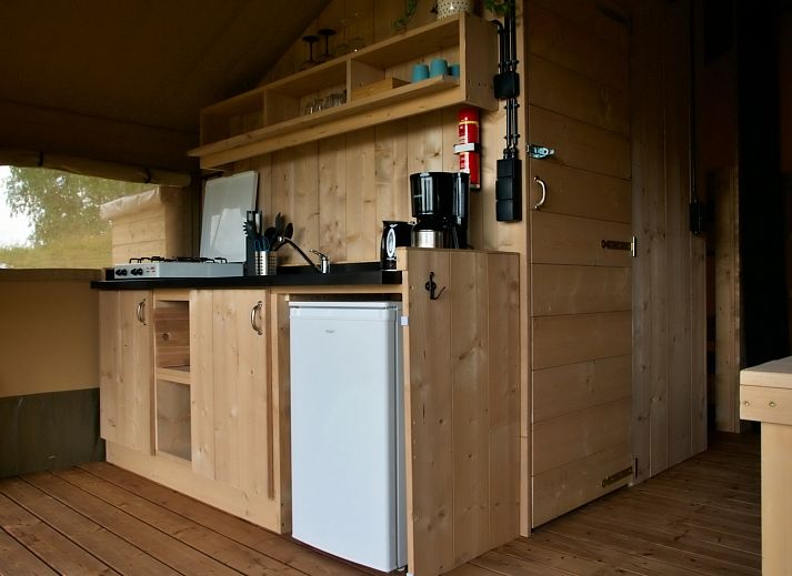 Interior of Safari tent incl. sanitary facilities in Lichtaart, Antwerp, Belgium. Cozy glamping lodge with kitchen and dining area.