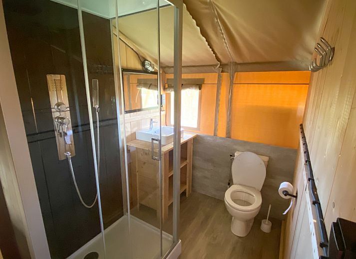 Cozy interior of Safari tent incl. sanitary facilities in Lichtaart, Antwerp. Glamping lodge with wooden furniture and natural atmosphere.