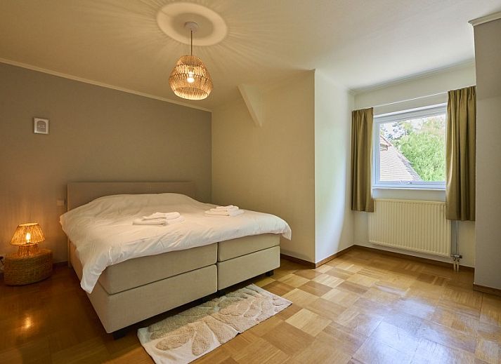 Villa Bosrijk in Lommel, Belgie, omgeven door groene natuur en een uitnodigende oprijlaan.