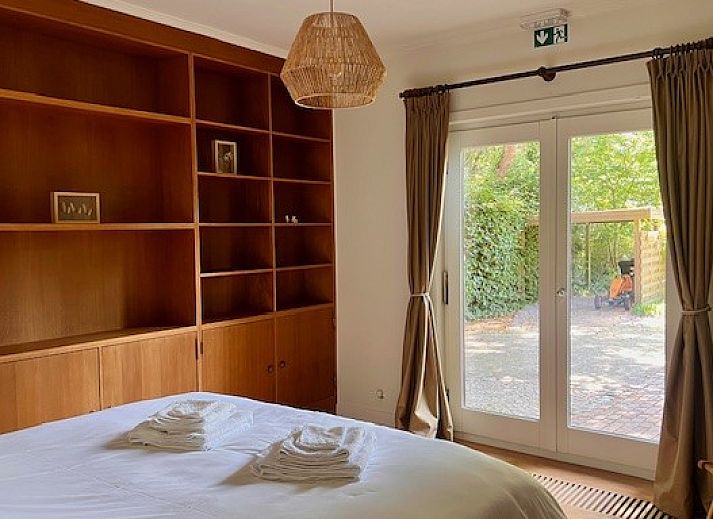 Sfeervolle slaapkamer met houten elementen in Villa Bosrijk, vakantiehuis in Lommel, Belgie.