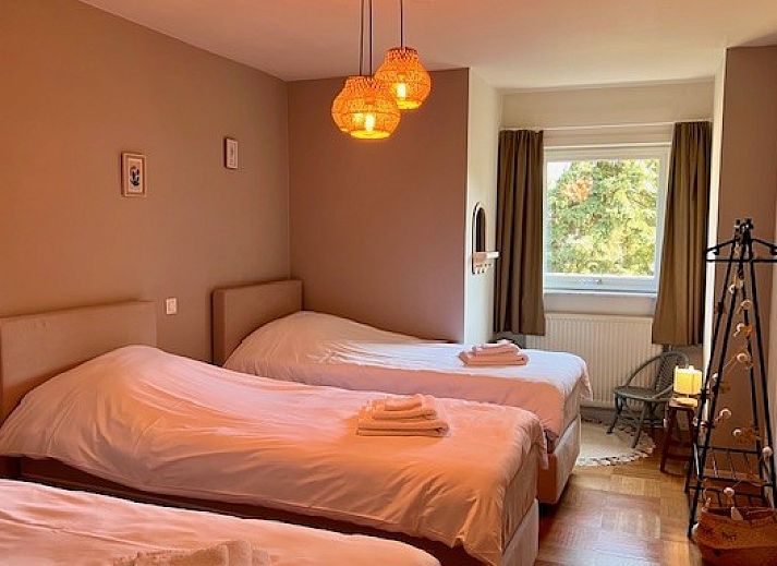 Sfeervolle slaapkamer met houten elementen in Villa Bosrijk, vakantiehuis in Lommel, Belgie.