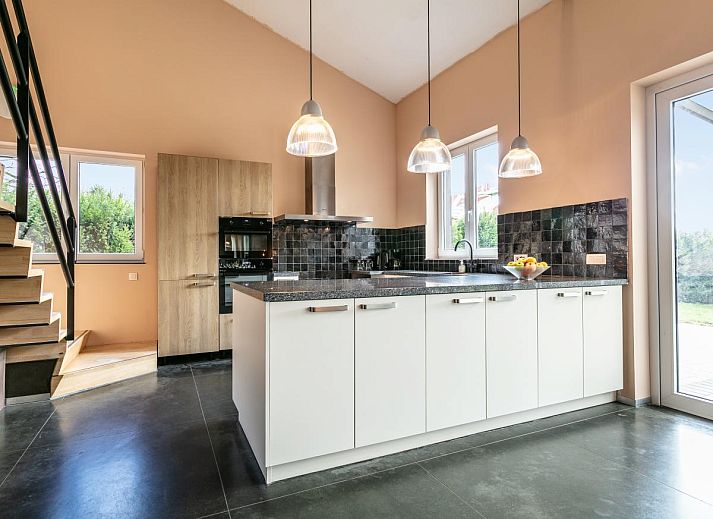 Gezellige eetkamer in vakantiehuis Ons Huis, Hechtel-Eksel, Limburg, Belgie met gedekte tafel en bloemen.