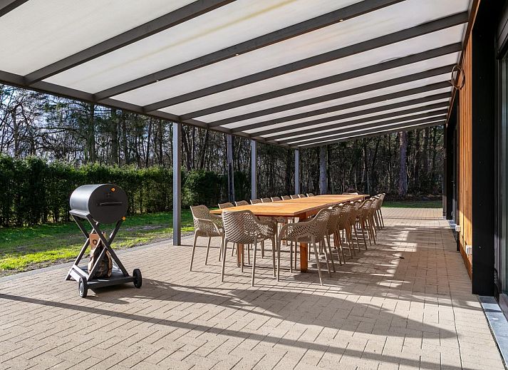 Gezellige eetkamer in vakantiehuis Ons Huis, Hechtel-Eksel, Limburg, Belgie met gedekte tafel en bloemen.