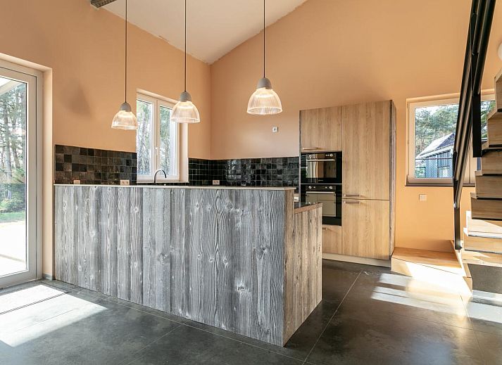 Stijlvolle eetruimte in vakantiehuis Ons Huis, Hechtel-Eksel, Limburg, Belgie met houten tafels en moderne verlichting.