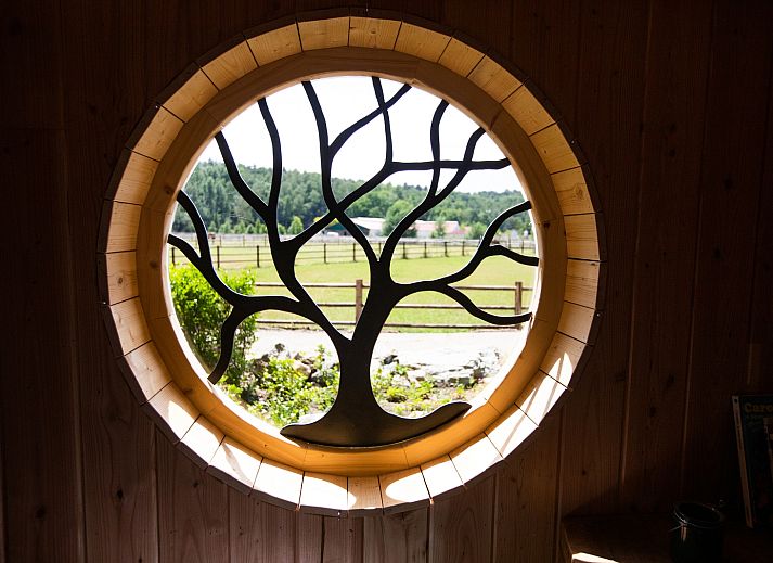 Geniet van de rustieke charme van Hobbit House 1 in Neeroeteren, Limburg, Belgie, met een gezellige buitenruimte en natuurlijke omgeving.