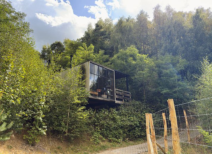 Watercabin met hottub in Neeroeteren, Limburg, Belgie, biedt een rustieke glamping ervaring te midden van weelderige natuur en bosrijke omgeving.