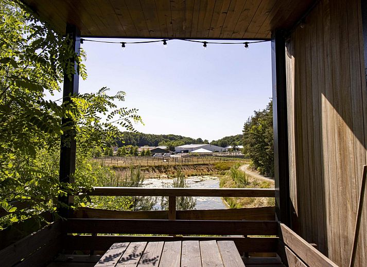 Watercabin met hottub in Neeroeteren, Limburg, Belgie, biedt een rustieke glamping ervaring te midden van weelderige natuur en bosrijke omgeving.