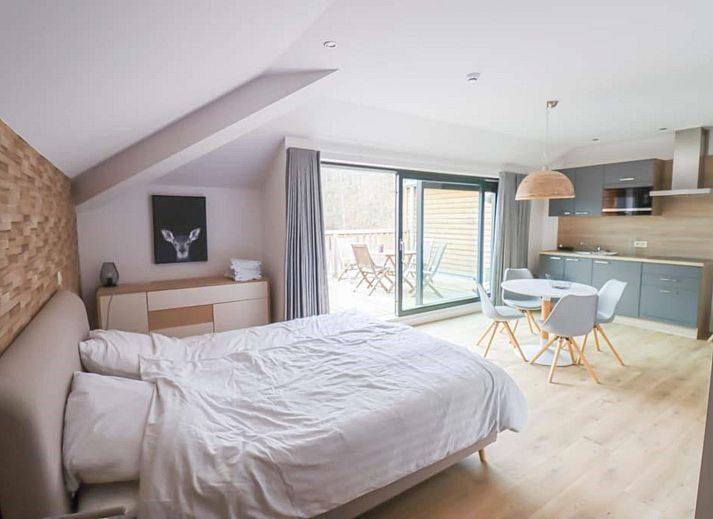 Fruehstueck auf der Terrasse des Plus Studio Ferienhauses in Neeroeteren, Limburg mit Blick auf die gruene Umgebung.