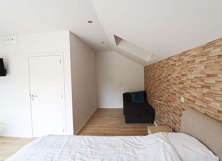 Fruehstueck auf der Terrasse des Plus Studio Ferienhauses in Neeroeteren, Limburg mit Blick auf die gruene Umgebung.