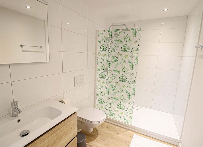 Fruehstueck auf der Terrasse des Plus Studio Ferienhauses in Neeroeteren, Limburg mit Blick auf die gruene Umgebung.