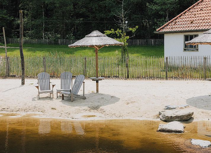 Binnenruimte van Comfort Classic vakantiehuis in Neeroeteren, Limburg, Belgie, met uitzicht op veranda en omliggende bossen.