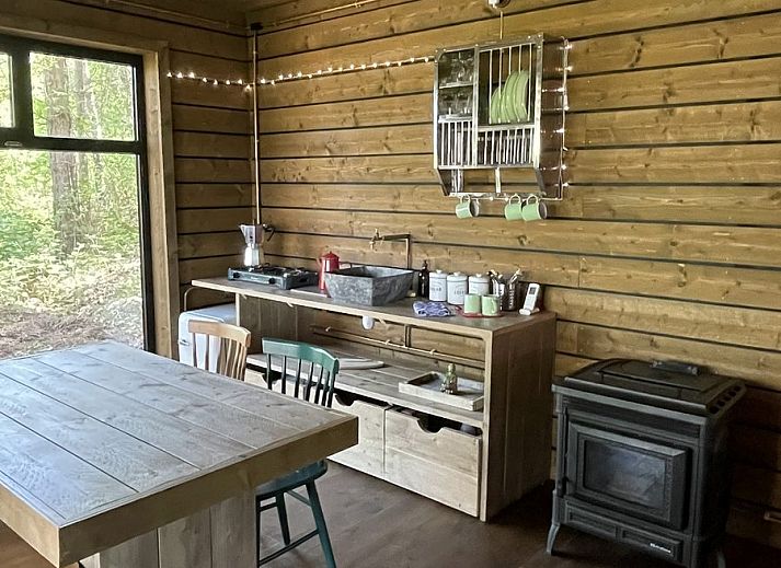 Comfort Sweet Wellness vakantiehuis in Neeroeteren, Limburg met houten terras en jacuzzi omringd door natuur.