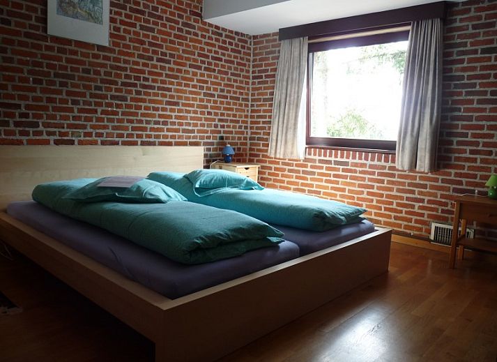 Entree van StadOase-Hasselt vakantiehuis in Limburg, Belgie met houten deur en bloempot.