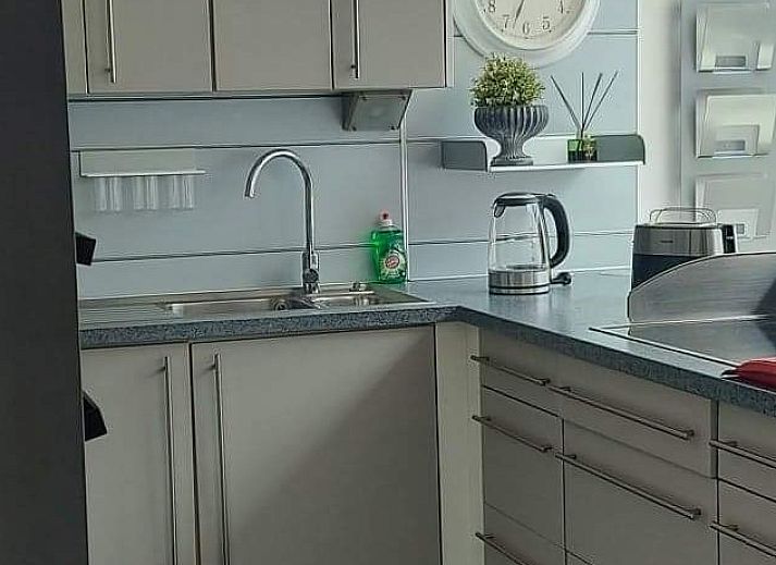 Gezellige zithoek bij 't Ouwershuys vakantiehuis in Opoeteren, Limburg, Belgie, met decoratieve muur en stoelen.