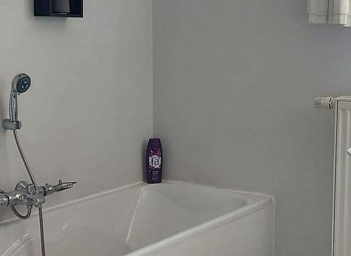 Gezellige zithoek bij 't Ouwershuys vakantiehuis in Opoeteren, Limburg, Belgie, met decoratieve muur en stoelen.
