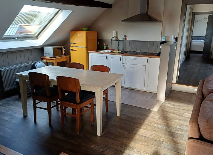 Gezellige keuken in Aan Maas & Grens vakantiehuis in Kinrooi, Limburg, Belgie, met houten tafel en retro koelkast.