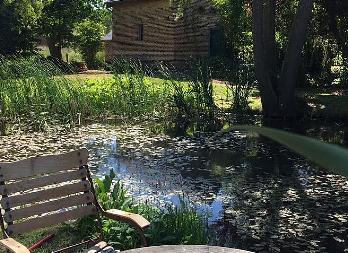 Cozy living room in Holiday Home in Sint-Truiden, Limburg, Belgium with wooden staircase and rustic decor.