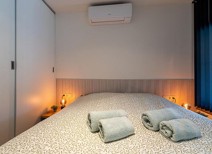 Knusse slaapkamer in Aperol Spritz vakantiehuis, Zutendaal, Limburg met sfeervolle verlichting.