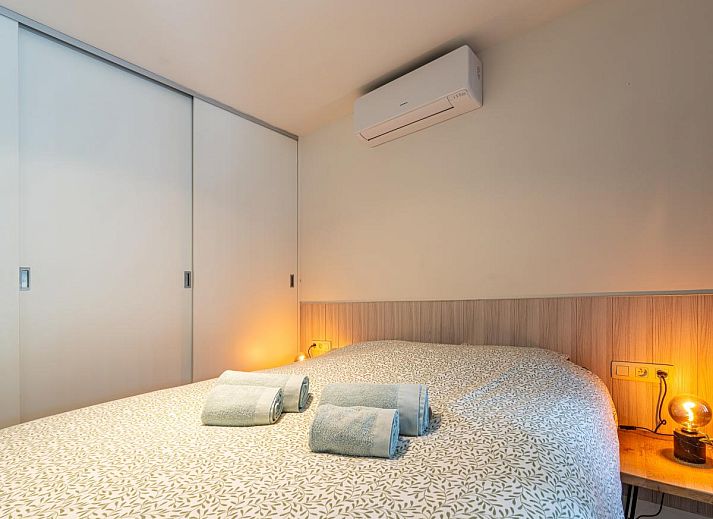 Knusse slaapkamer in Aperol Spritz vakantiehuis, Zutendaal, Limburg met sfeervolle verlichting.