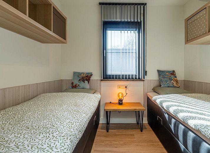 Knusse slaapkamer in Aperol Spritz vakantiehuis, Zutendaal, Limburg met sfeervolle verlichting.