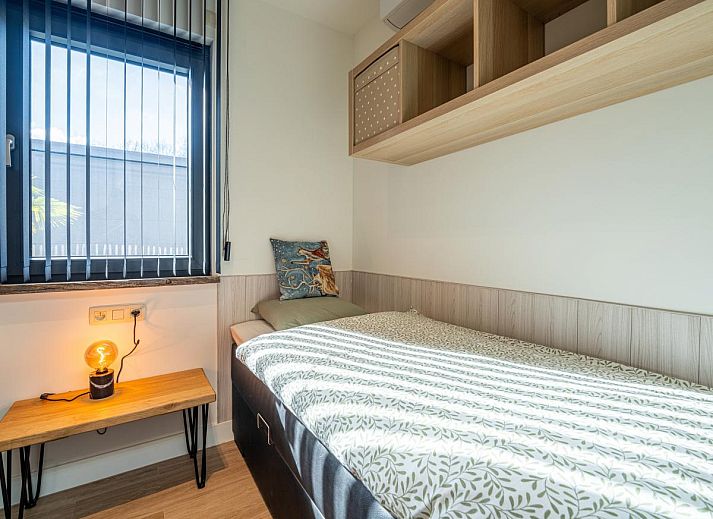Knusse slaapkamer in Aperol Spritz vakantiehuis, Zutendaal, Limburg met sfeervolle verlichting.