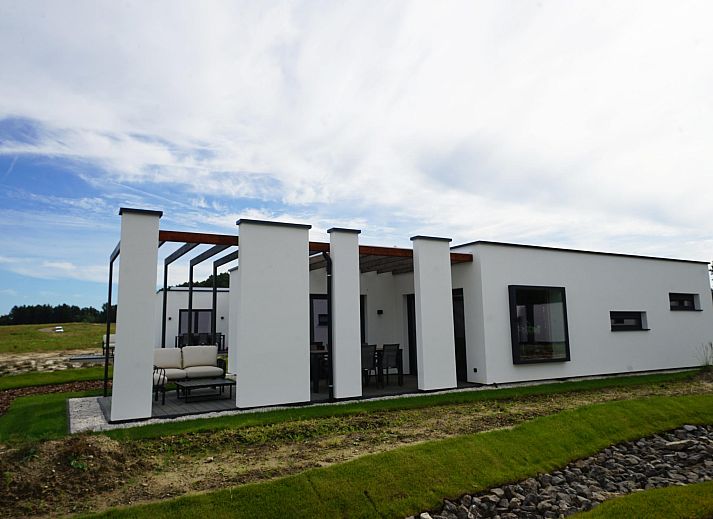 Vrijstaande woning in Zutendaal, Limburg biedt een prachtig uitzicht op het meer en de groene omgeving vanuit het moderne vakantiehuis.