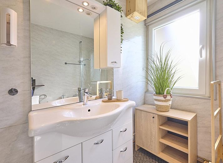 Gezellige eetruimte in vakantiehuis Barri, Zutendaal, Limburg, met een ronde eettafel en moderne houten inrichting.