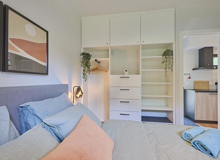 Gezellige woonkamer in De Eekhoorn vakantiehuis, Zutendaal, met comfortabele bank en uitzicht op de tuin.
