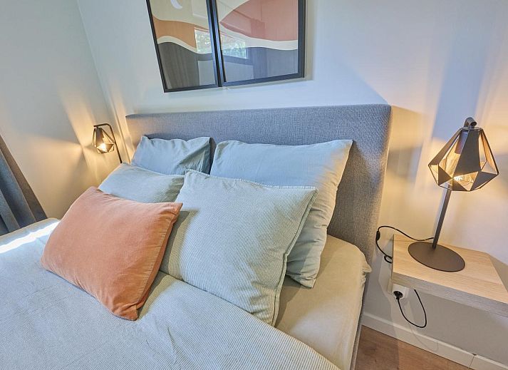 Gezellige woonkamer in De Eekhoorn vakantiehuis, Zutendaal, met comfortabele bank en uitzicht op de tuin.