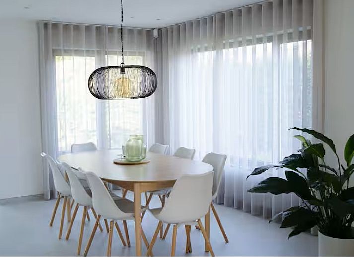 Lichte woonkamer in Ten Huyze Bucholt, een vakantiehuis met tuinsauna in Bocholt, Limburg, Belgie, met uitzicht op de groene omgeving.